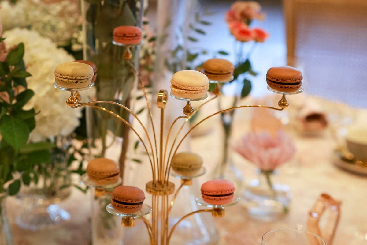 Árbol dorado de macarons entre flores en la estación de té
