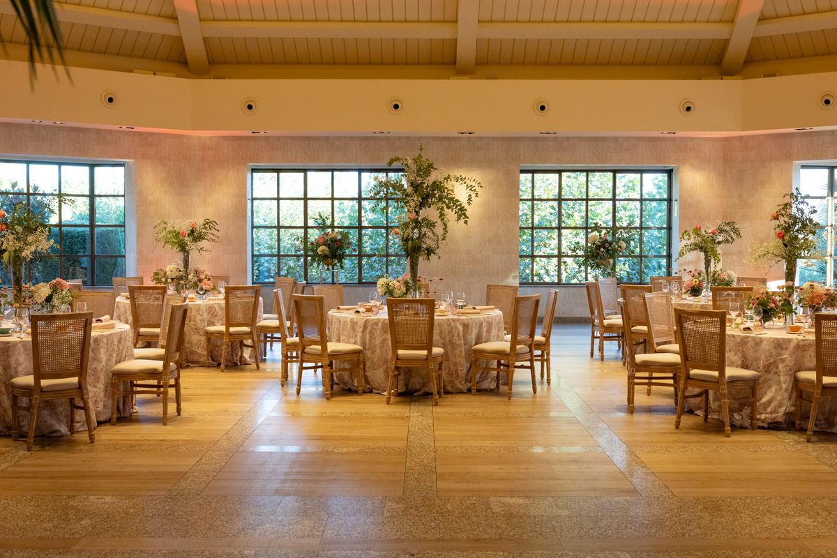 El salón de El Atrio montado para la fiesta del té, con manteles de toile rosa y centros de flores