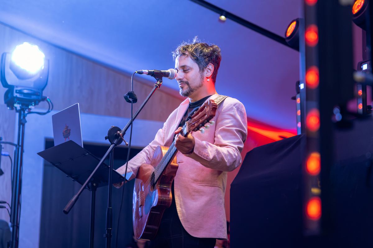 Músico con guitarra actuando en directo en el salón de La Pradera