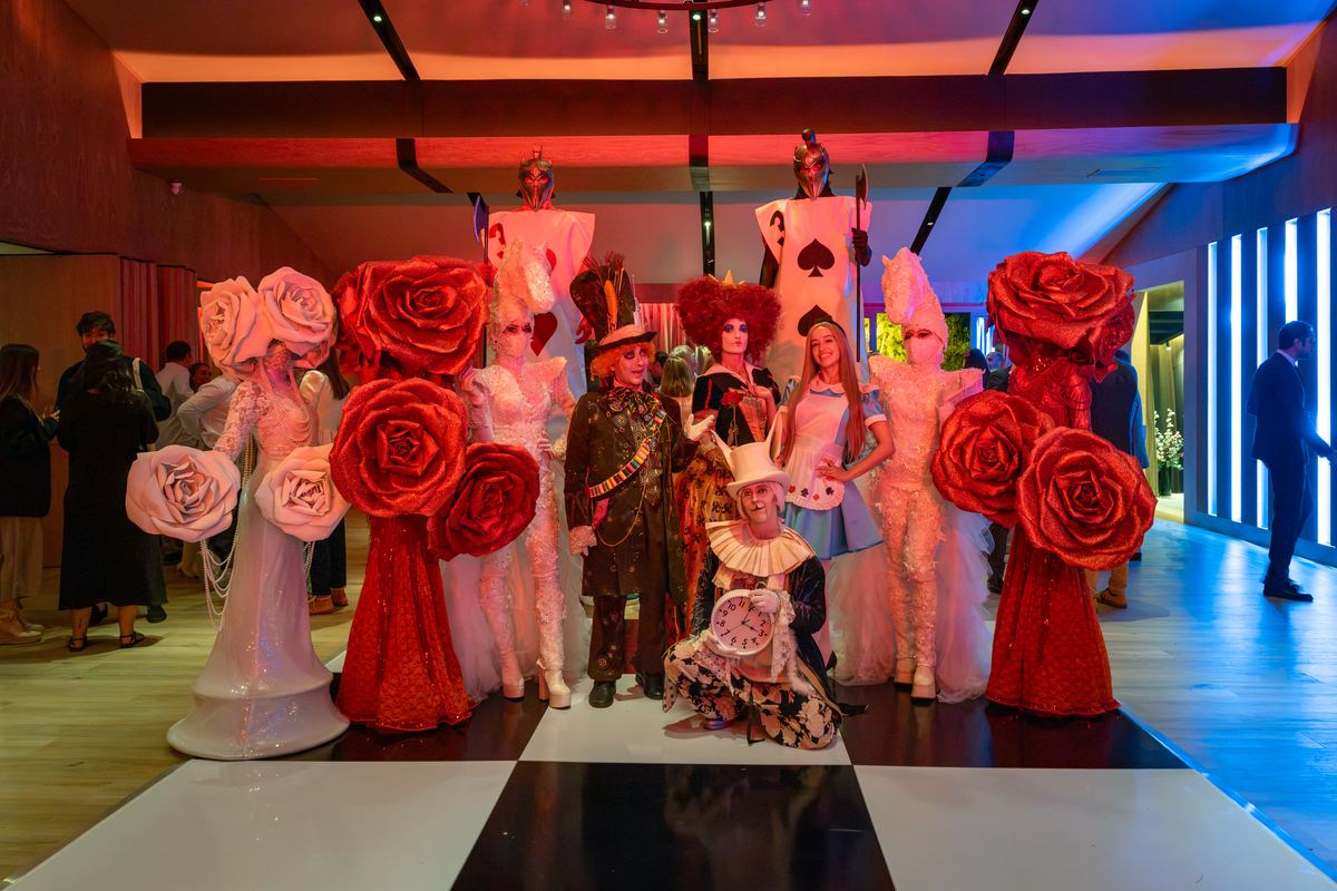El elenco de personajes de Alicia en el País de las Maravillas posando en el salón de La Pradera
