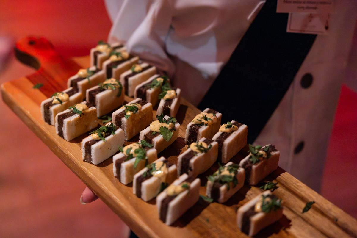 Bandeja de mini sándwiches servida por un camarero