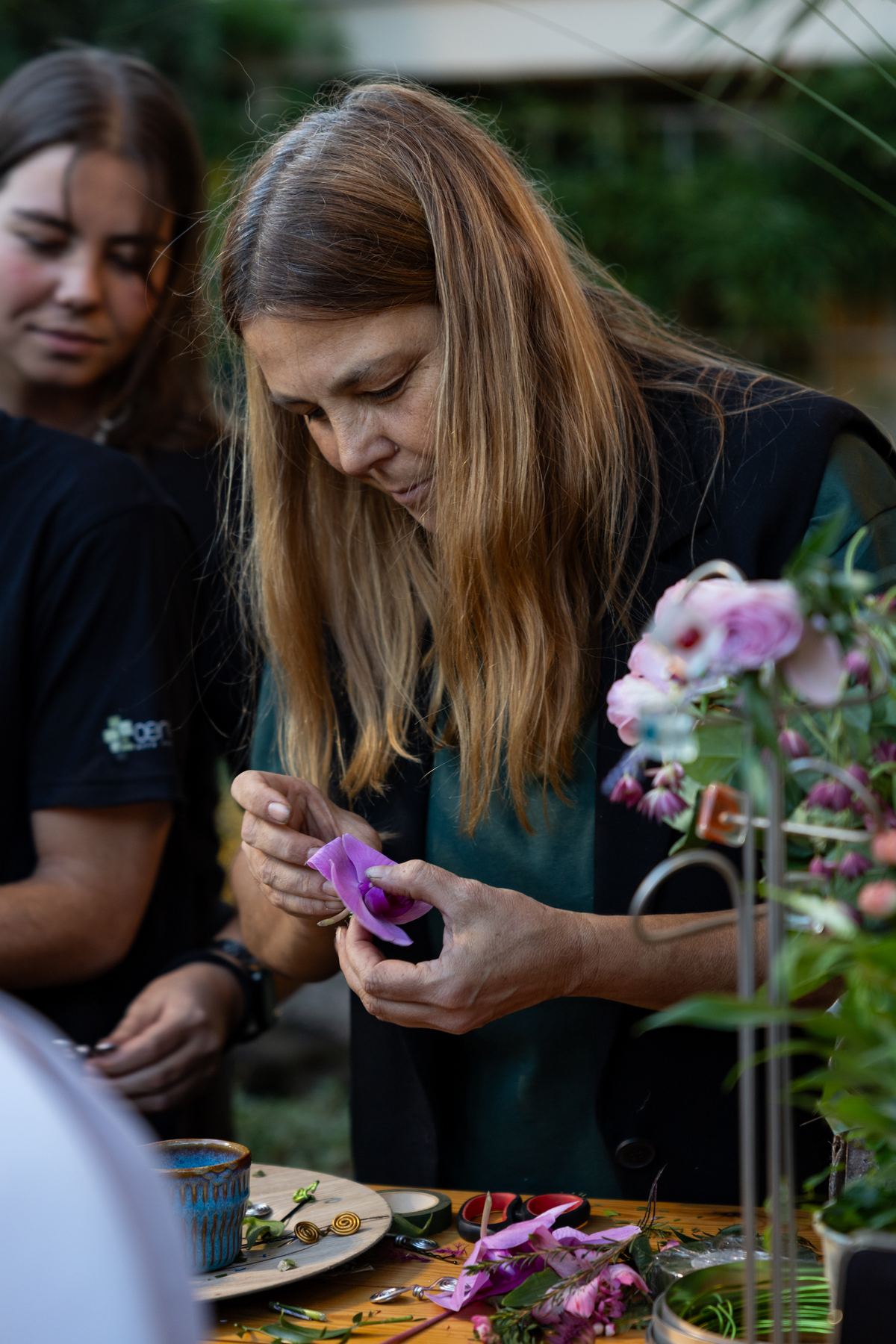 Invitada eligiendo flores en la estación de floristas que montaban tocados al momento