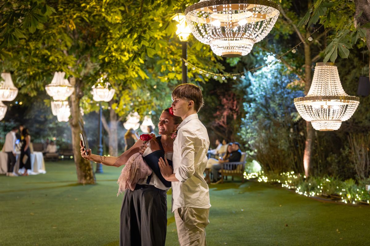 Invitados bajo las lámparas de cristal del jardín