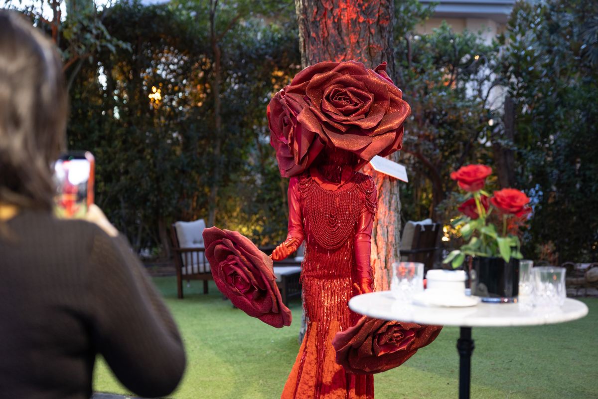 Actor vestido de rosa gigante en el jardín de la Reina Roja