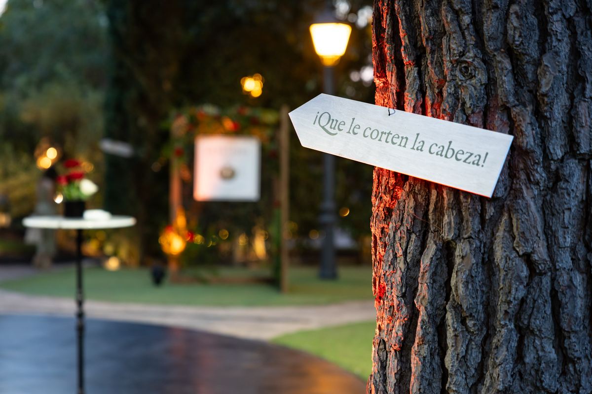 Cartel con el texto «¡Que le corten la cabeza!» clavado en un pino del jardín