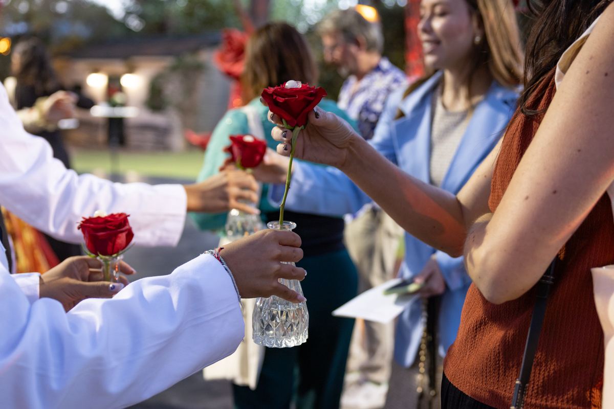 Entrega de rosas rojas en jarrón de cristal a los invitados