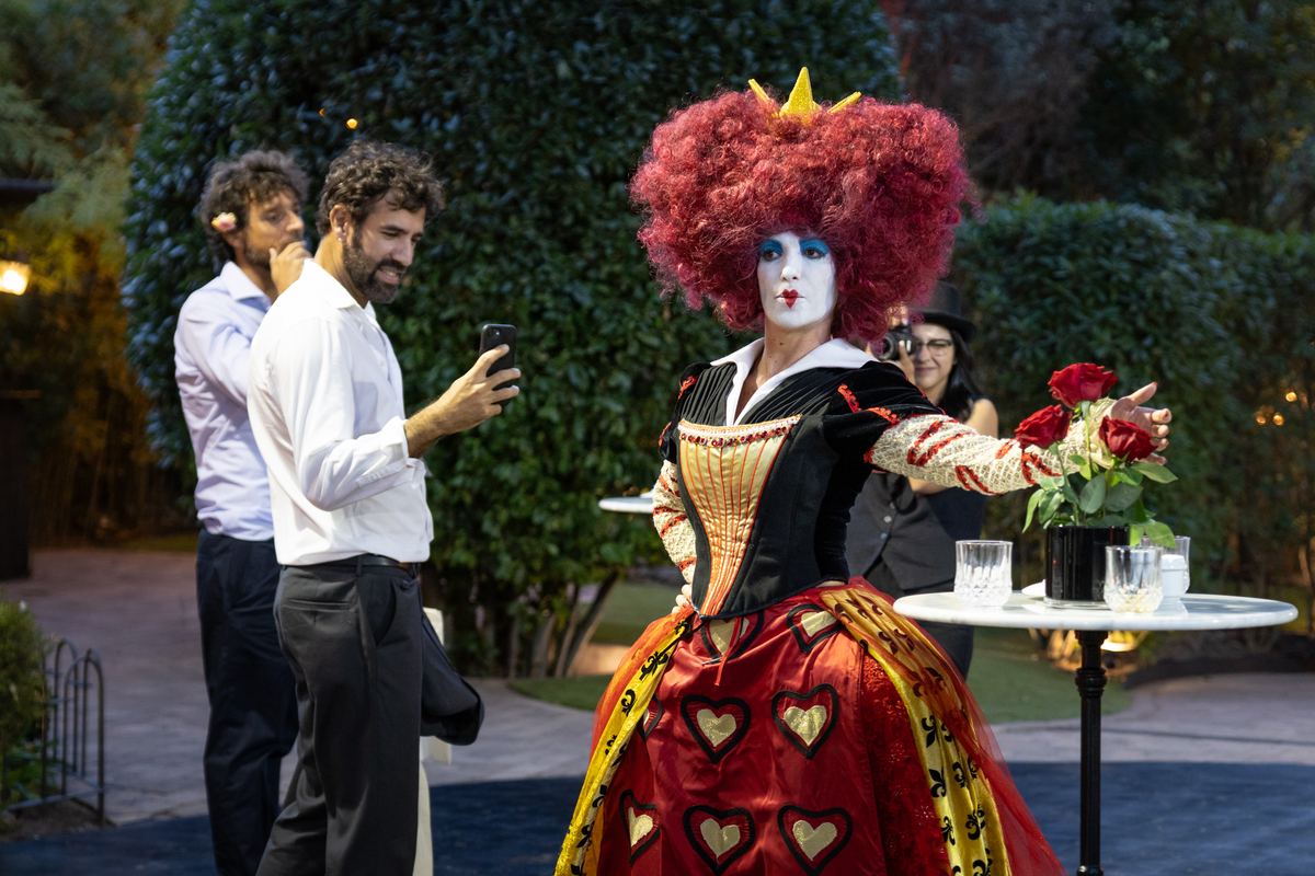 La Reina Roja, en personaje, en el jardín de La Pradera junto a los invitados